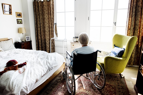 Woman sitting in wheelchair, facing the window